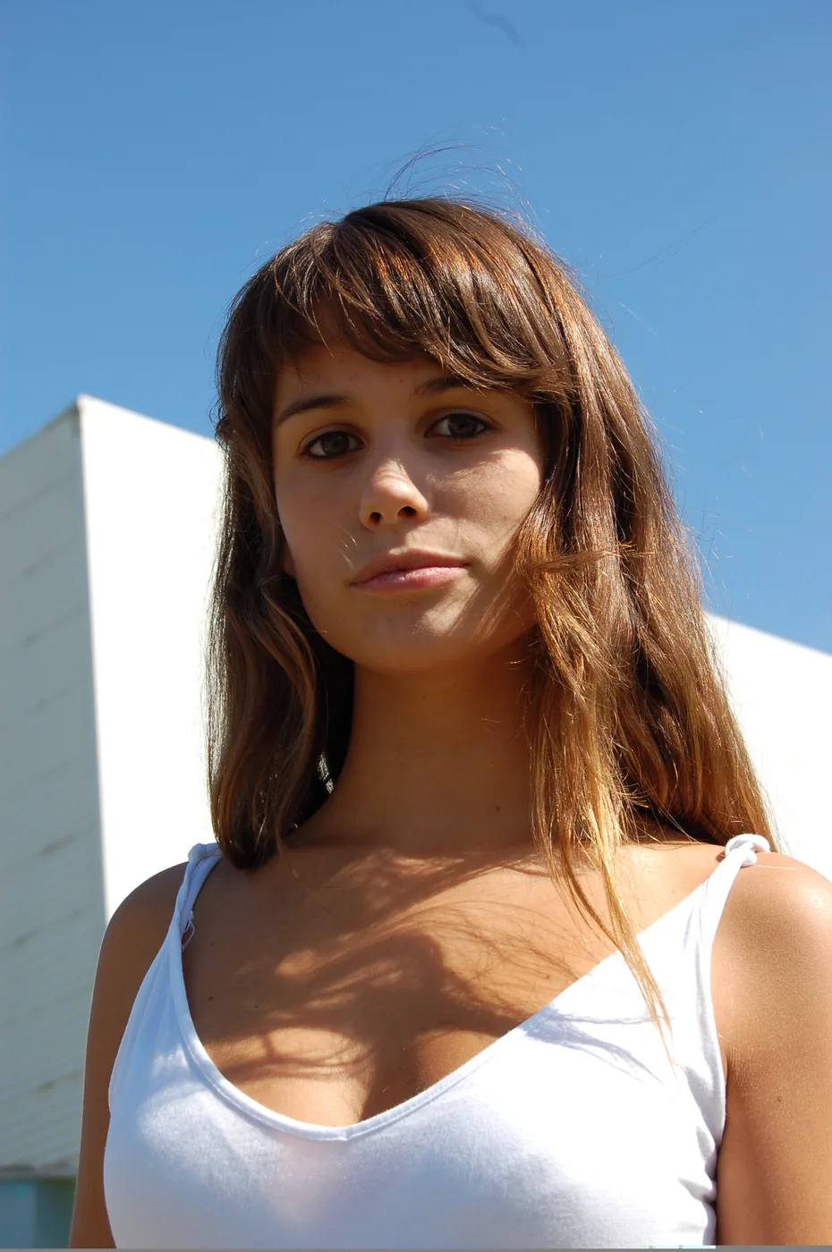 Tournage du clip Lucy (Live Saver Remix) de JEALOUSY, 2005 — portrait vertical actrice souriant, décor blanc clip Lucy JEALOUSY 2005